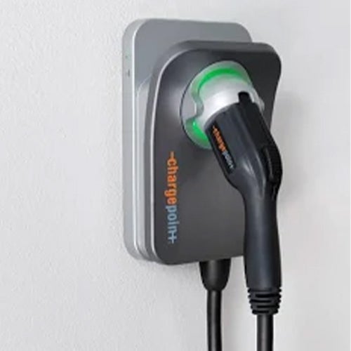 A ChargePoint home electric vehicle charger mounted on a white wall with a green status light.