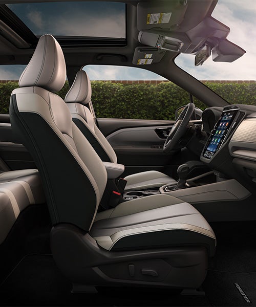 Interior view of a Subaru Forester with grey and black leather seats, a large touchscreen, and a sunroof.