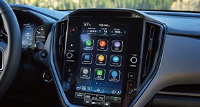 The large vertical 11.6-inch touchscreen display showing navigation and climate controls.