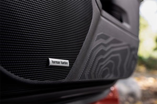 A close up view of the Subaru Forester dashboard featuring the premium infotainment system and Harman Kardon speaker grilles in a modern cabin.