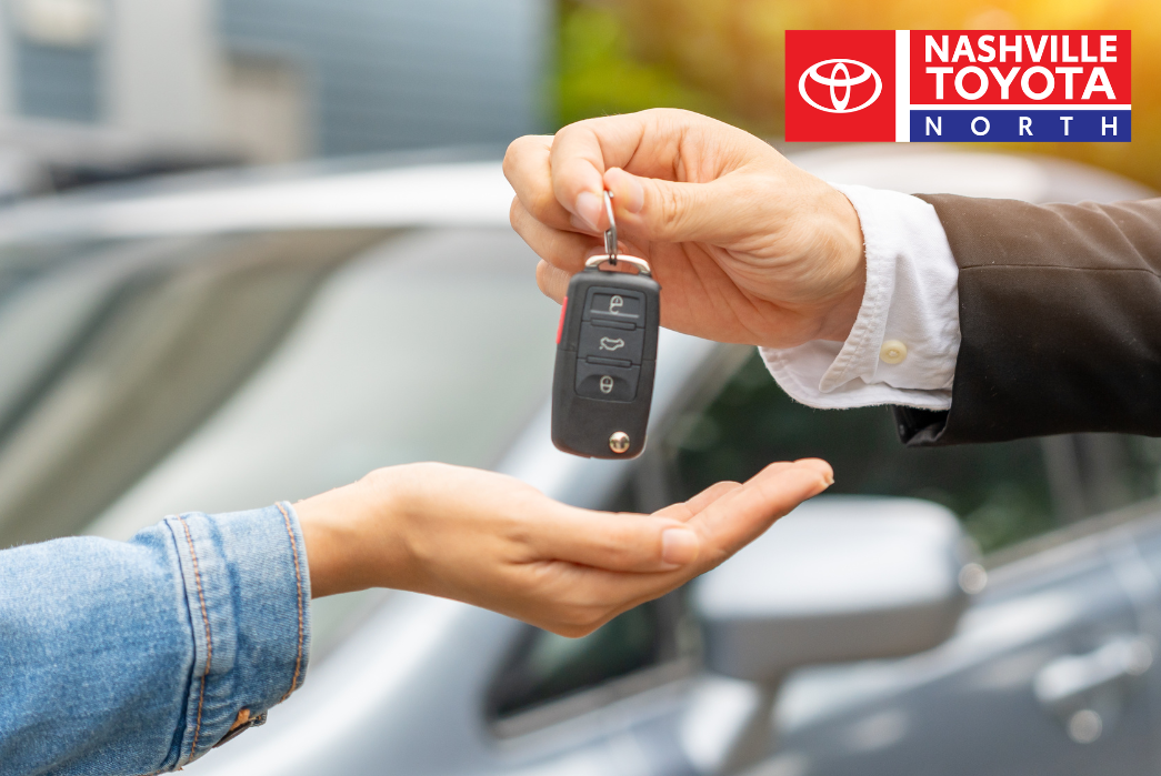 a person handing a car key to another person