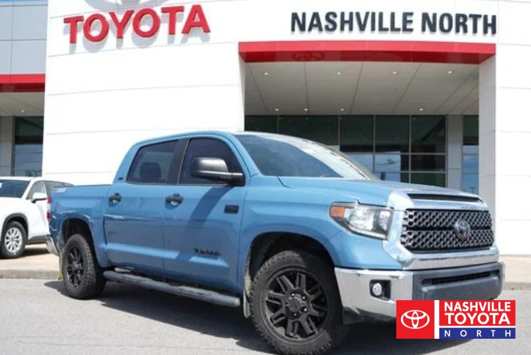 A blue Toyota Tundra pickup truck parked in front of a Toyota dealership with "Nashville North" signage.