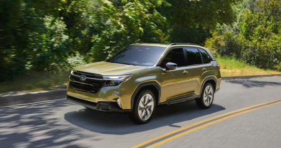 Exterior front 3/4 action majore of the Forester Hybrid in Autumn Green Metallic drive on a road
