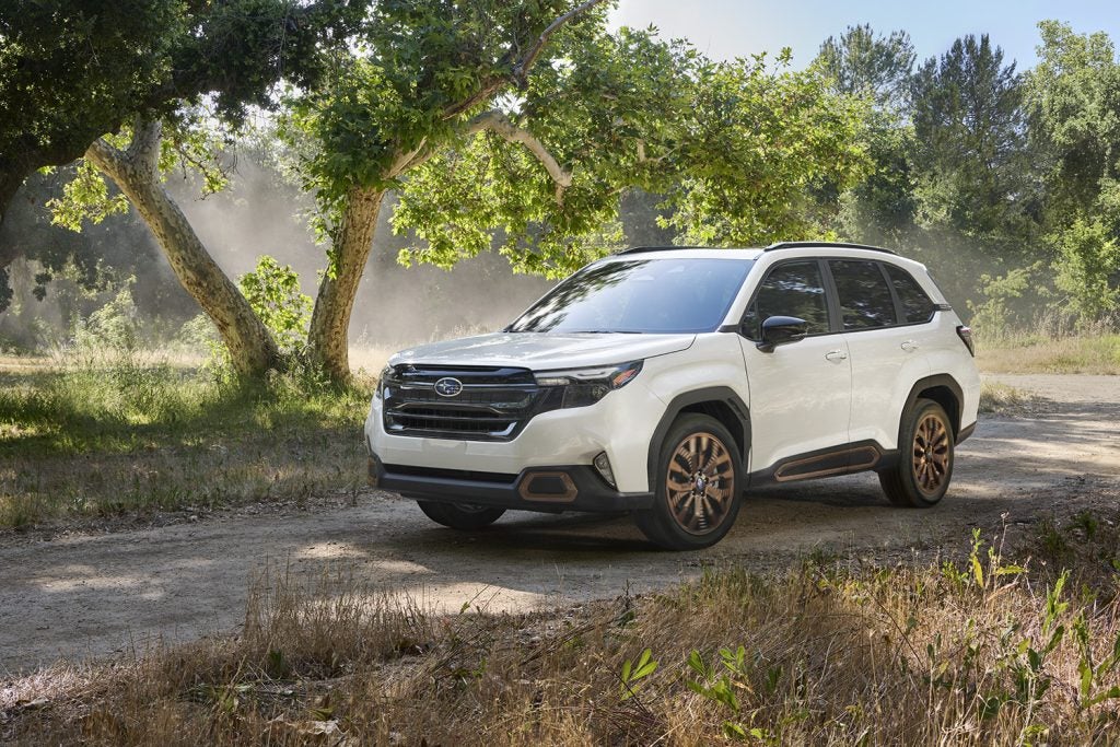 Subaru Forester SUV showcasing off-road capability on a wooded dirt trail