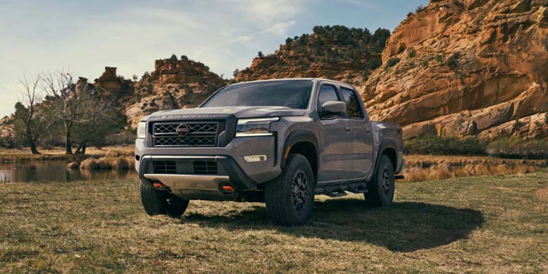 A 2023 Nissan Frontier in front of a rock formation.