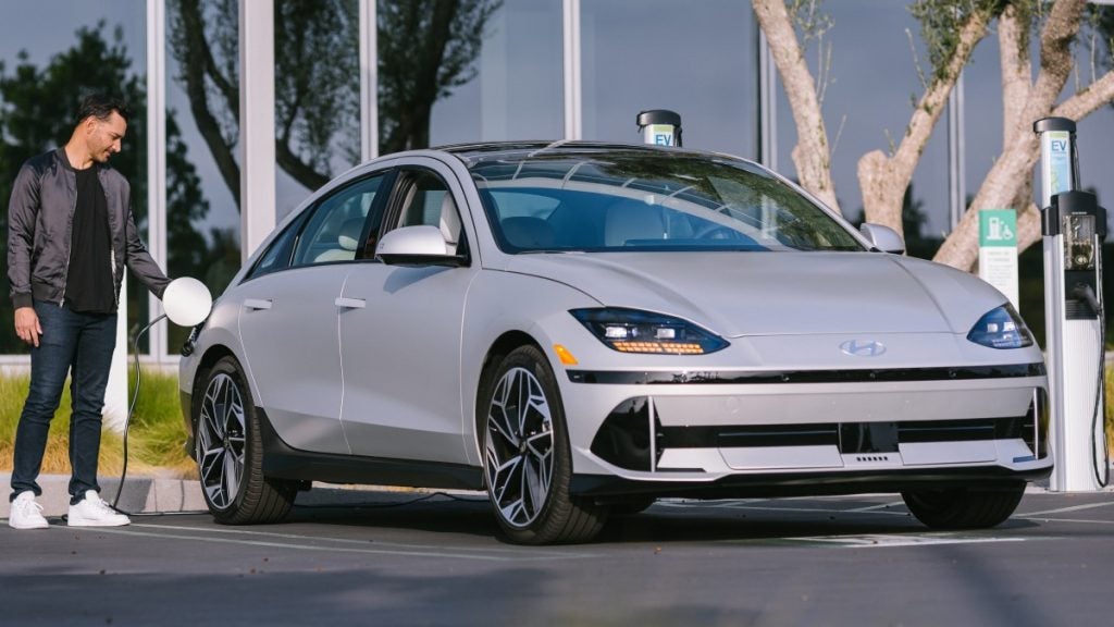 Front side view of a 2025 IONIQ 6 parked and plugged into a charger