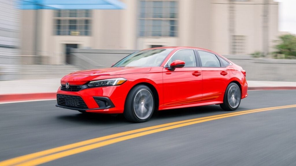 2026 Honda Civic Sedan Touring driving on a city street.