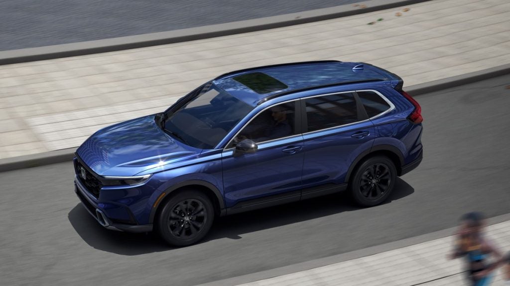 2023 Honda CR-V Sport Touring driving on a road.