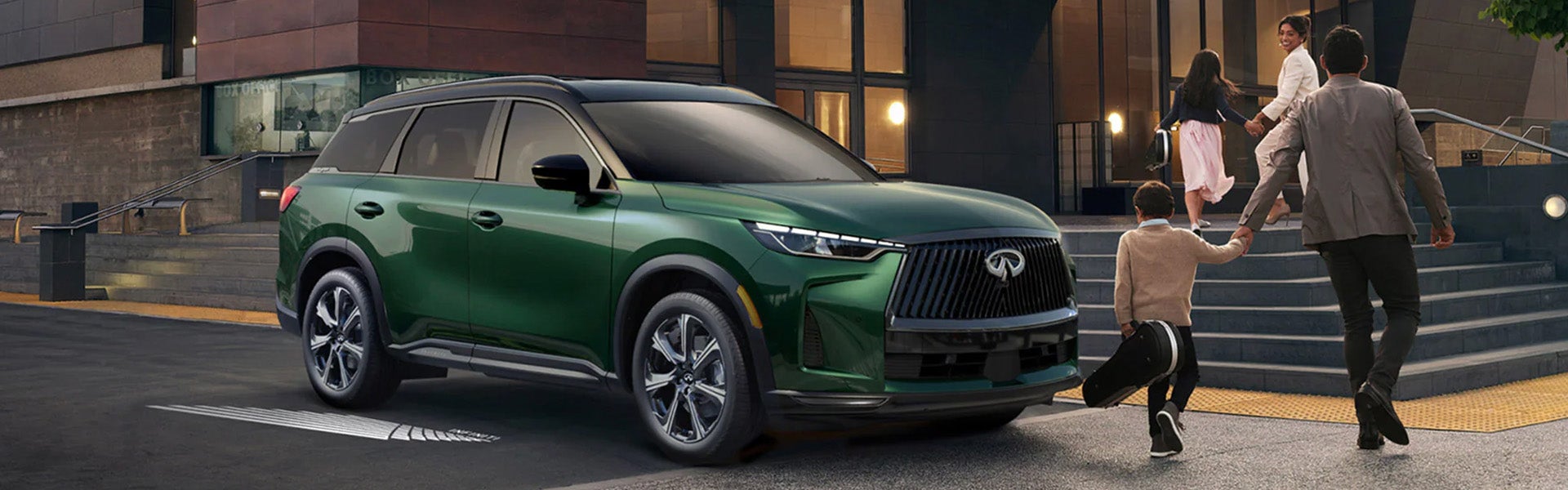 INFINITI QX60 parked in front of a modern building in Lexington, KY, showcasing its sleek design and elegance.