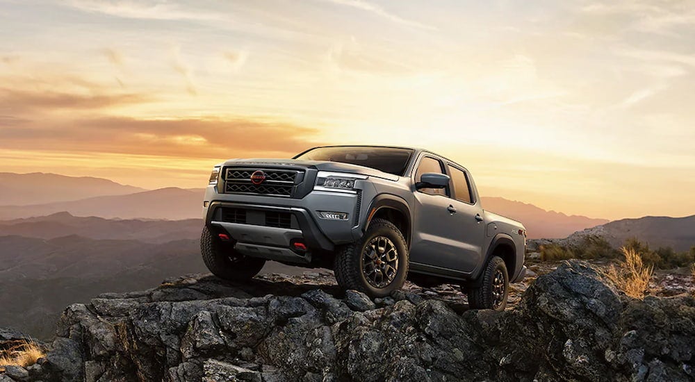 Grey 2026 Nissan Frontier Pro-4X parked off-road on a hill.