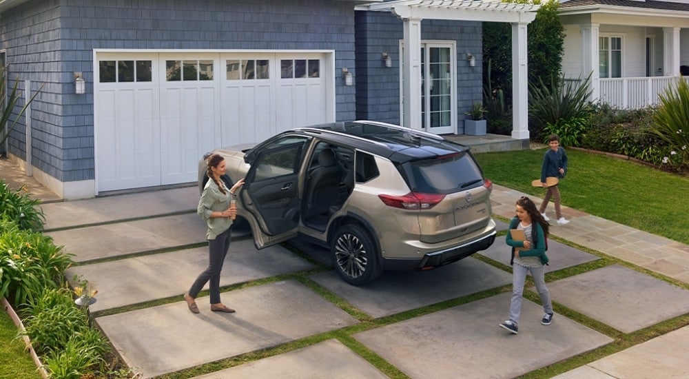 A gold 2025 Nissan Rogue from the rear at an angle.