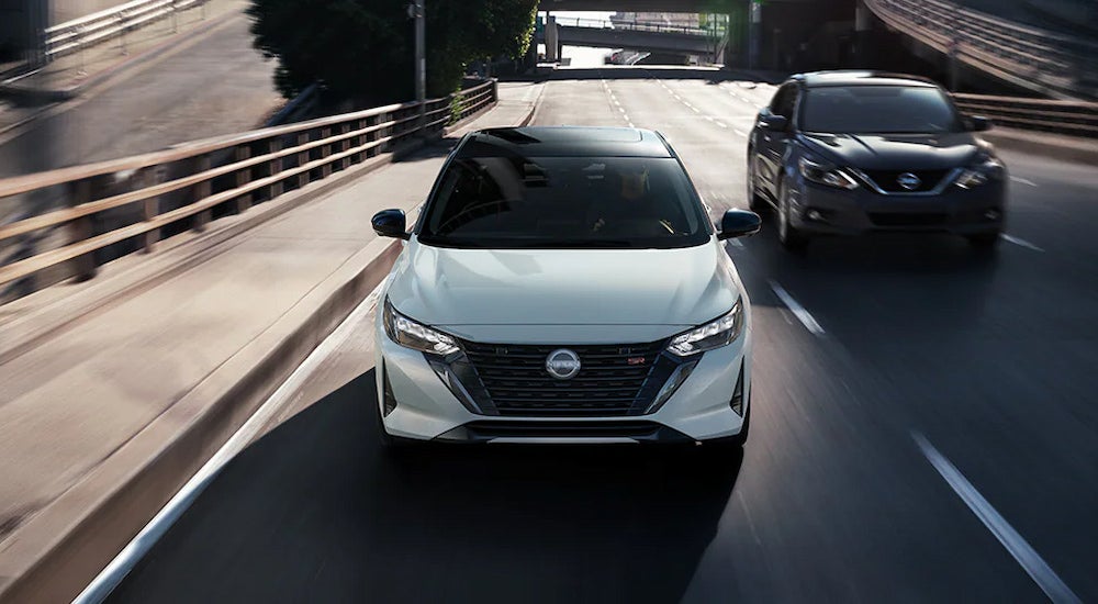 Head-on view of a white 2024 Nissan Sentra SR driving up an on-ramp.