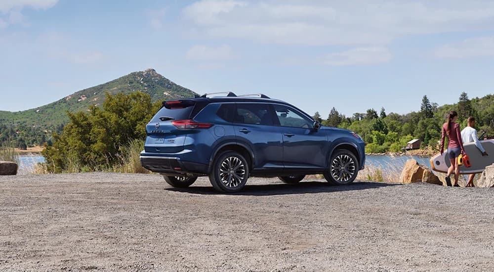 Rear of a blue 2025 Nissan Rogue parked off-road.