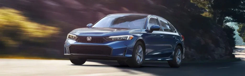 Blue Honda Civic sedan driving on a scenic road surrounded by trees
Honda Civic showcasing sleek exterior styling, modern design, and dynamic performance on the road