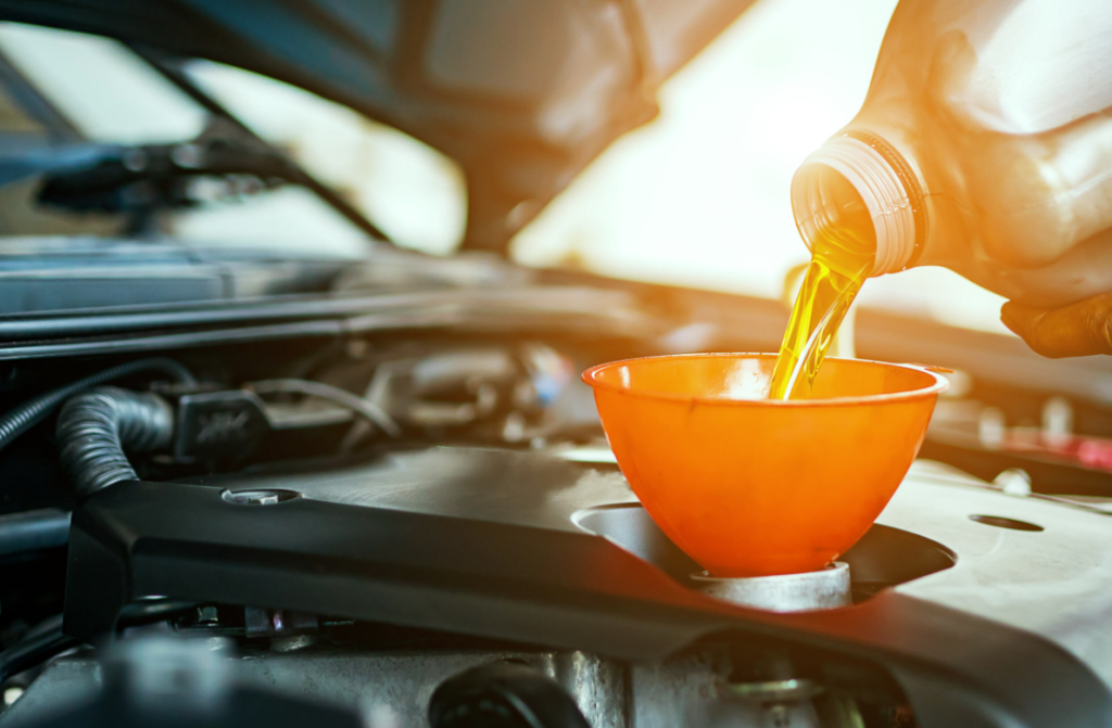 An auto repair technician changing oil.