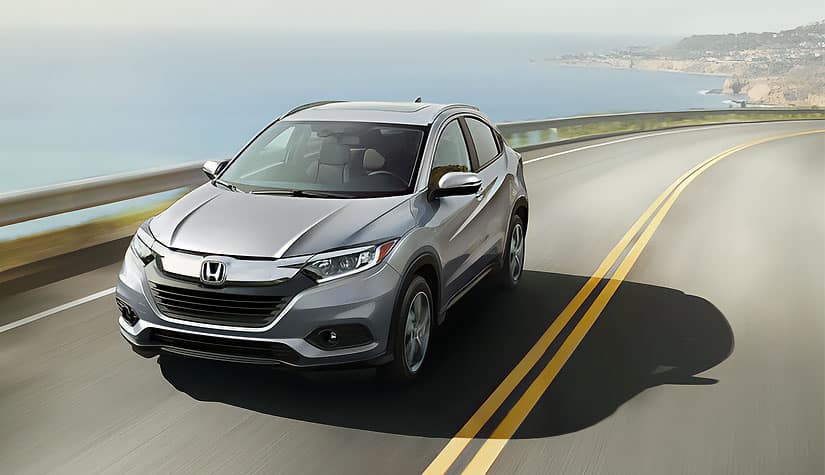 a silver honda hr-v driving down a highway 