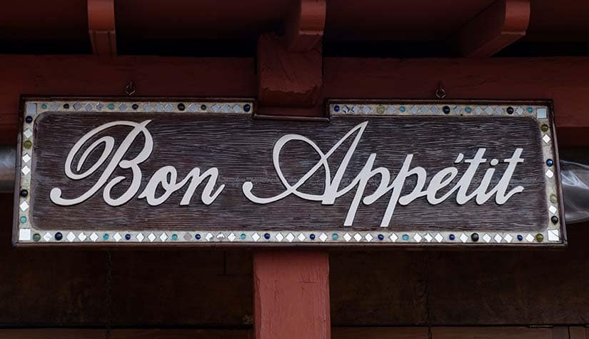 a wood sign with the words "bon appetit" written in fancy font 