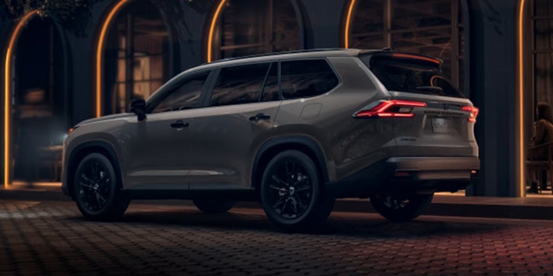 Gray Toyota Grand Highlander parked outside a building at night.