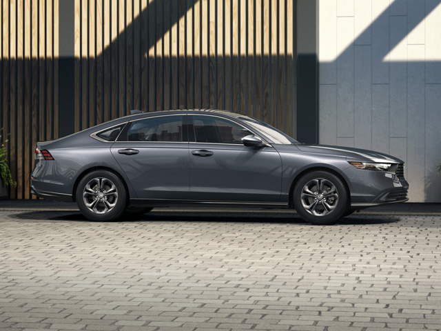 A silver sedan side view parked next to a building