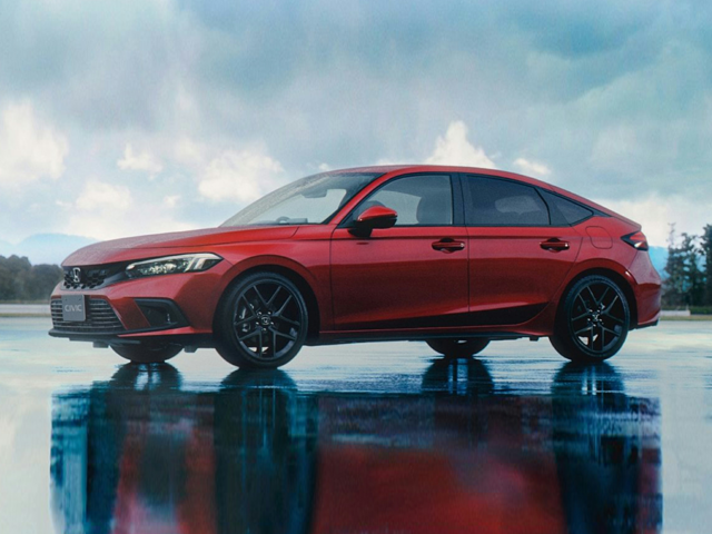 A red Honda vehicle on a rainy day parked outside