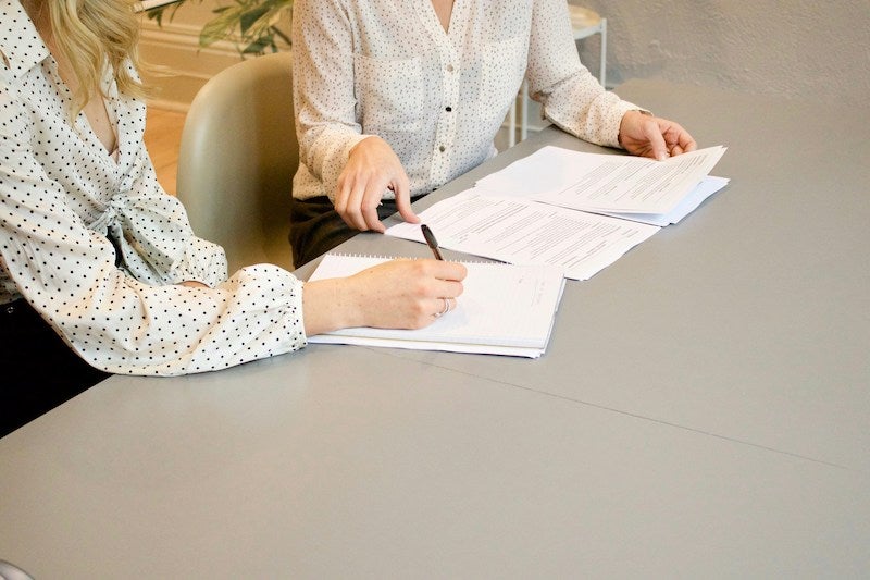 Two women review the financing details about buying a new Lincoln