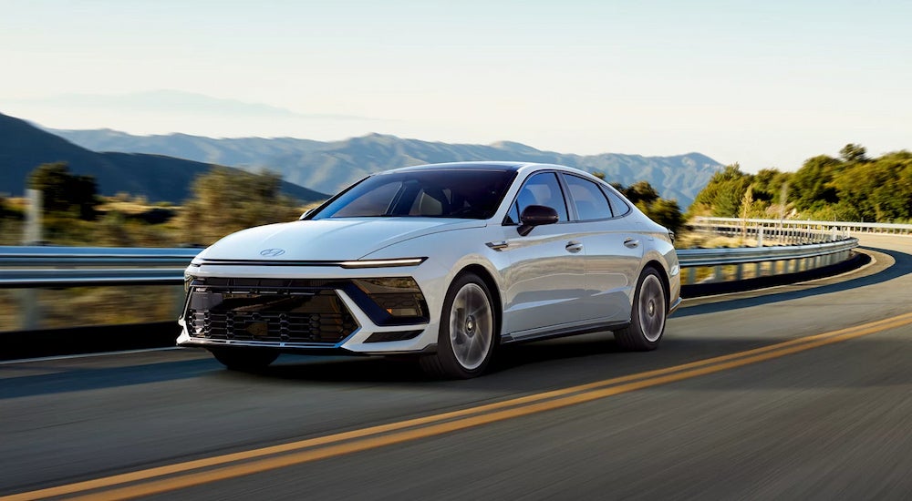 A white 2024 Hyundai Sonata N Line driving on an open highway.