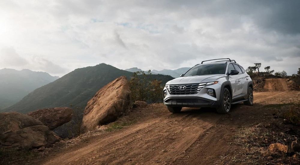 A white 2024 Hyundai Tucson XRT parked on a dirt trail.