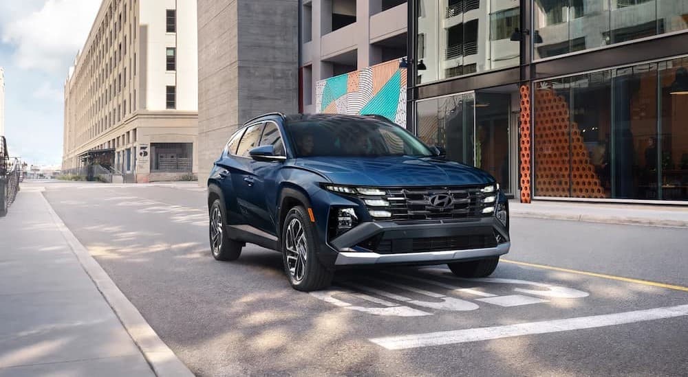 A blue 2025 Hyundai Tucson for sale in Knoxville driving in a city.