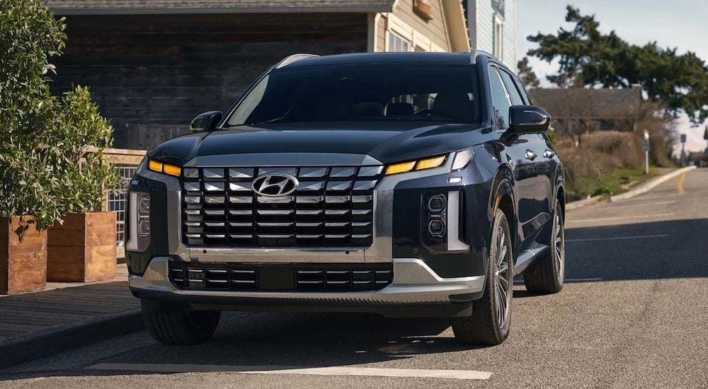 A blue 2025 Hyundai Palisade is shown from the front at an angle.