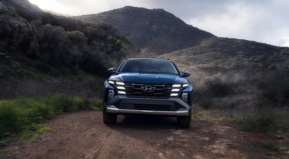 Head-on view of a blue 2025 Hyundai Tucson Limited driving off-road.