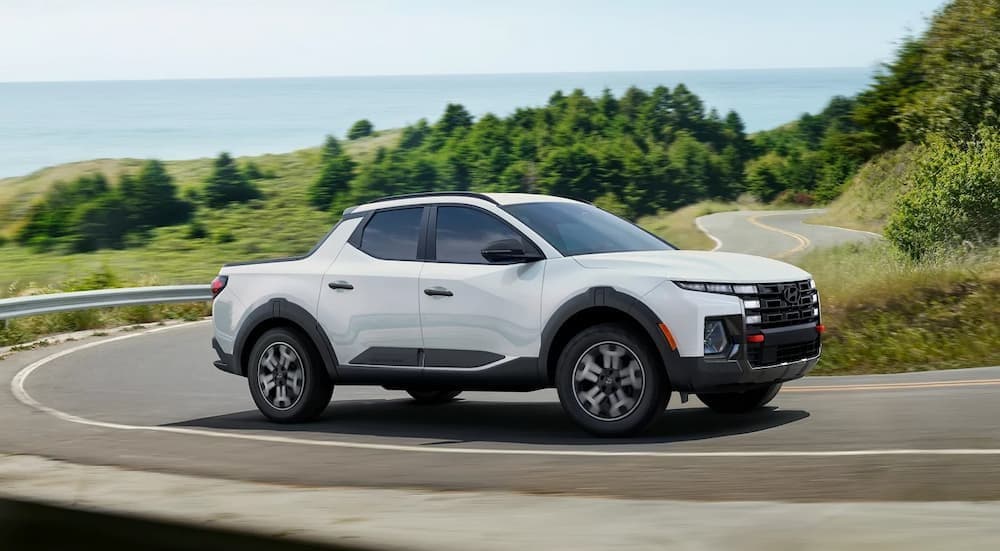 A white 2026 Hyundai Santa Cruz driving on a highway.