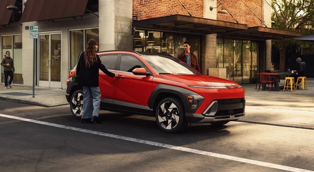 Orange 2026 Hyundai Kona parked outside of a shop in a city