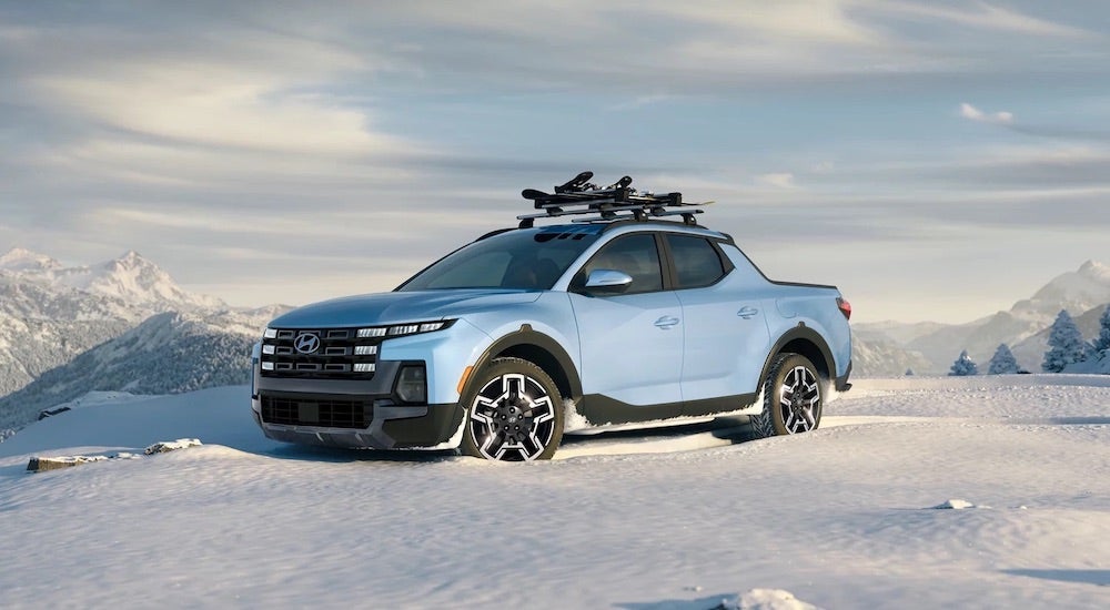 A blue 2025 Hyundai Santa Cruz parked and angled left on a snow field.