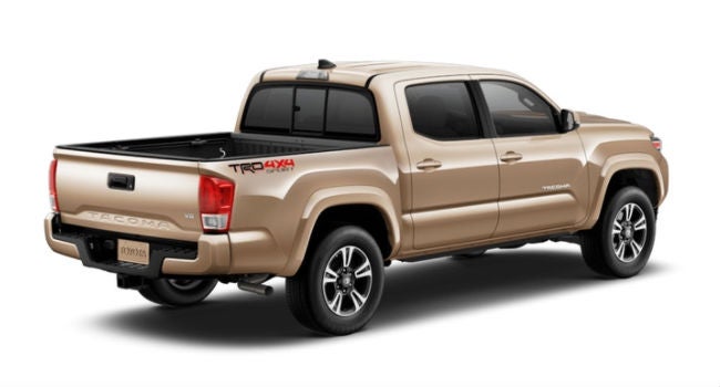 A rear right quarter view of the 2018 Tacoma in a Quicksand paint color