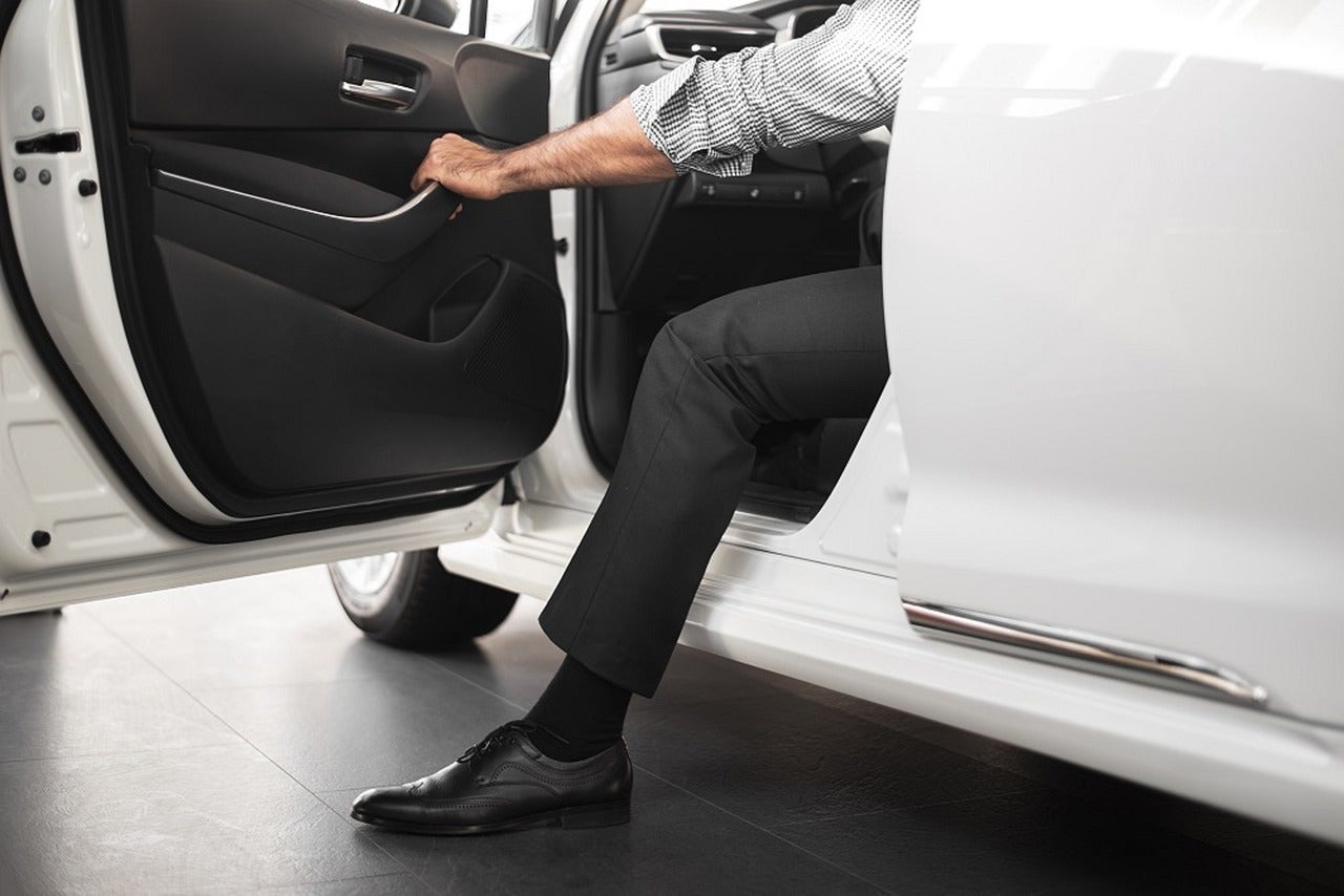 A person stepping out of a white car