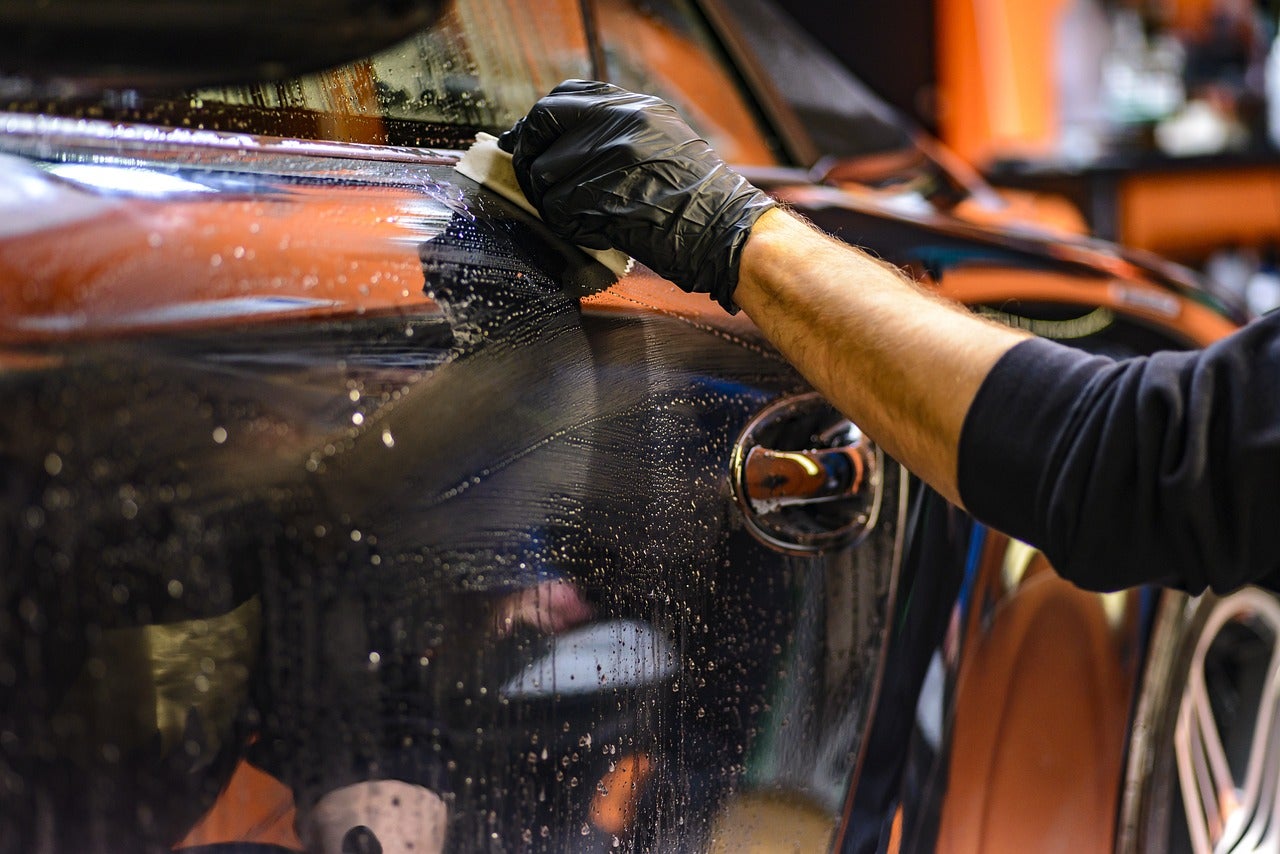 A person wiping a car