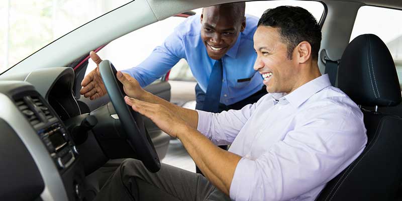 A man sitting in a vehicle about to take a test drive