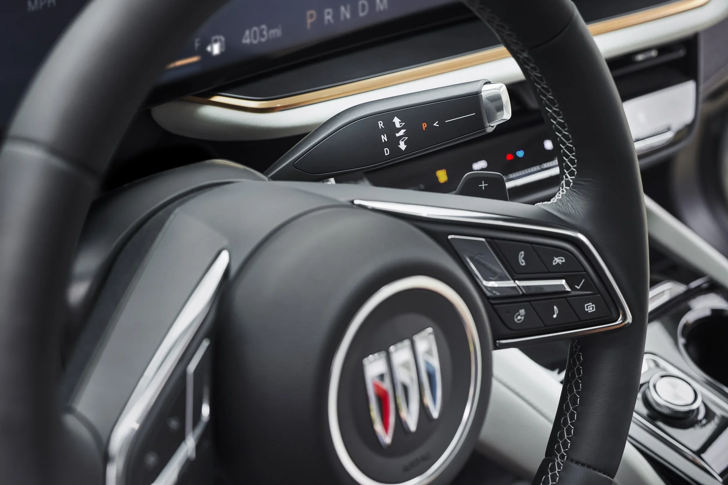 Buick Envision interior detail with steering wheel controls, column shifter and digital gauge cluster