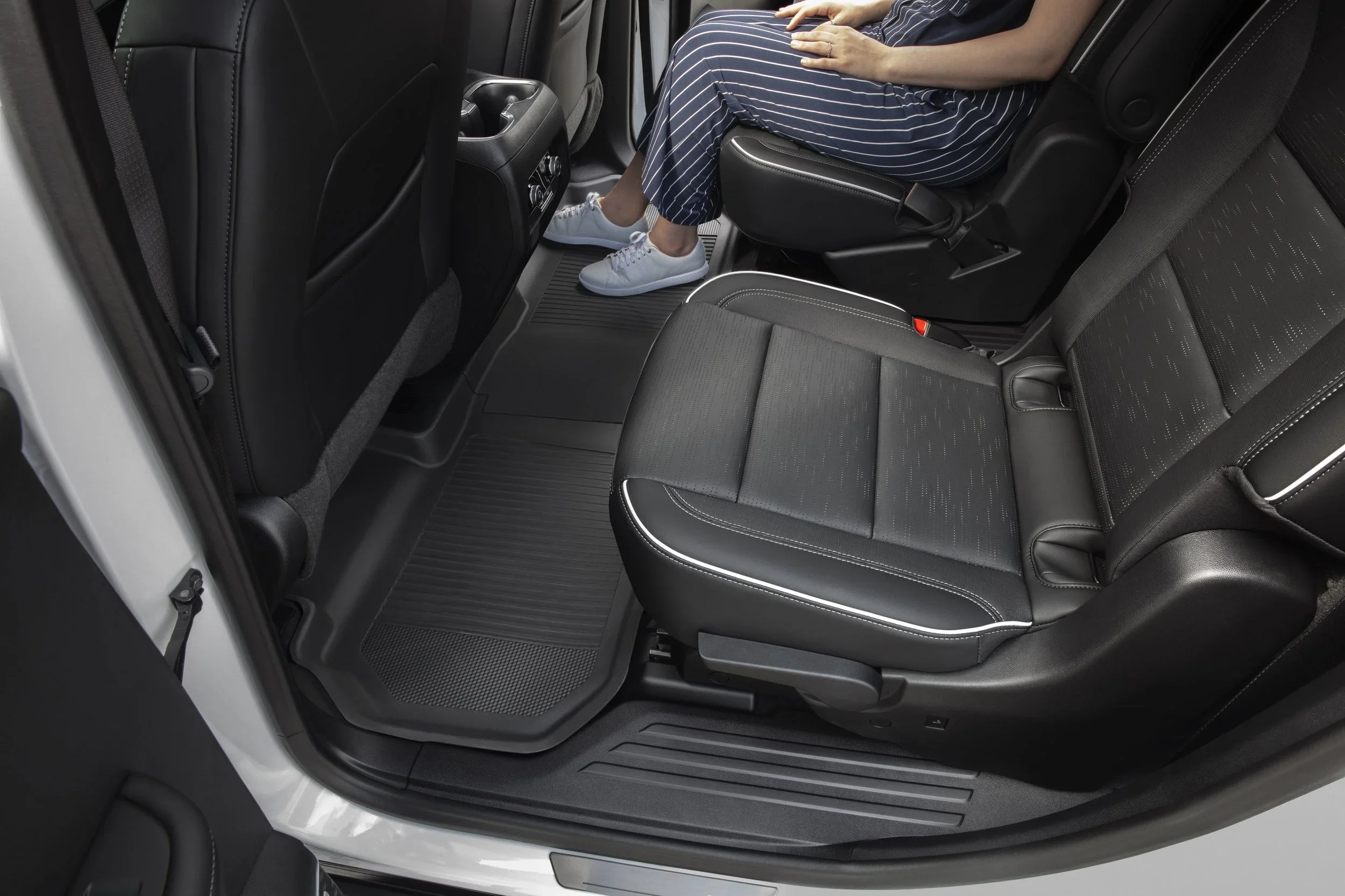 Buick Enclave second-row interior with black leather seats and open-door legroom