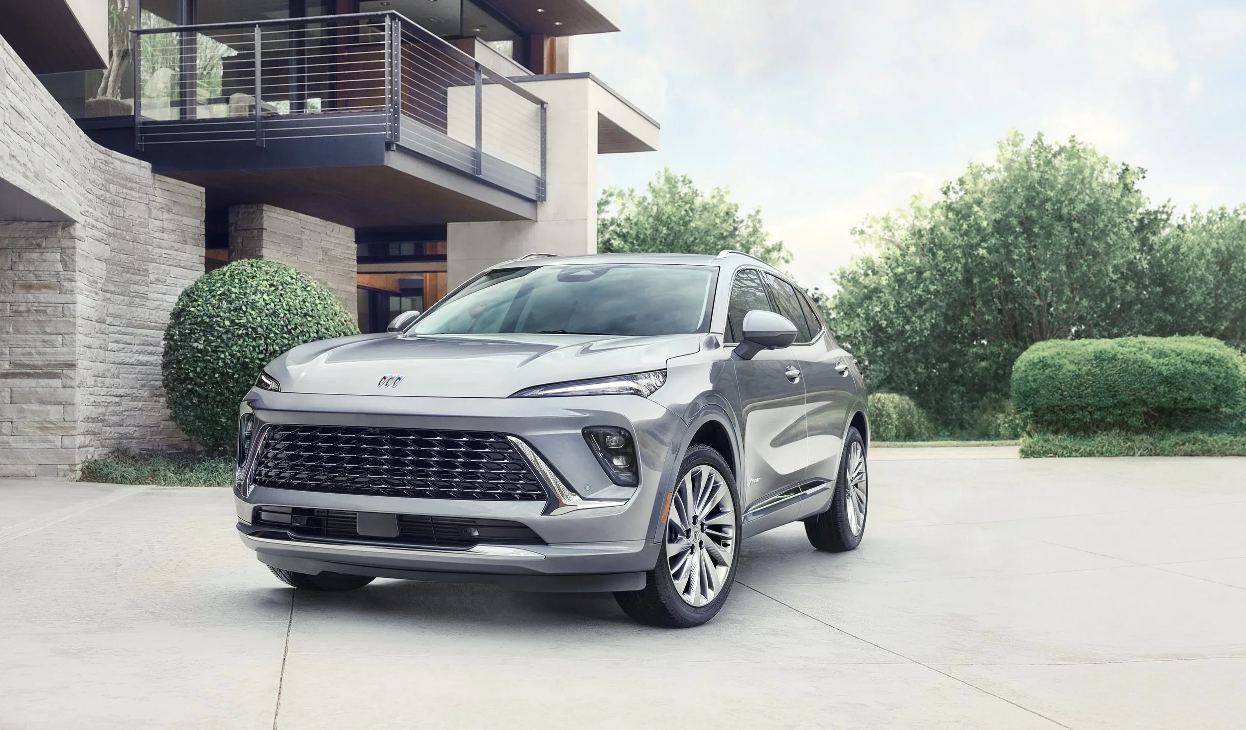 Silver Buick Envision Avenir parked in the driveway of a modern home