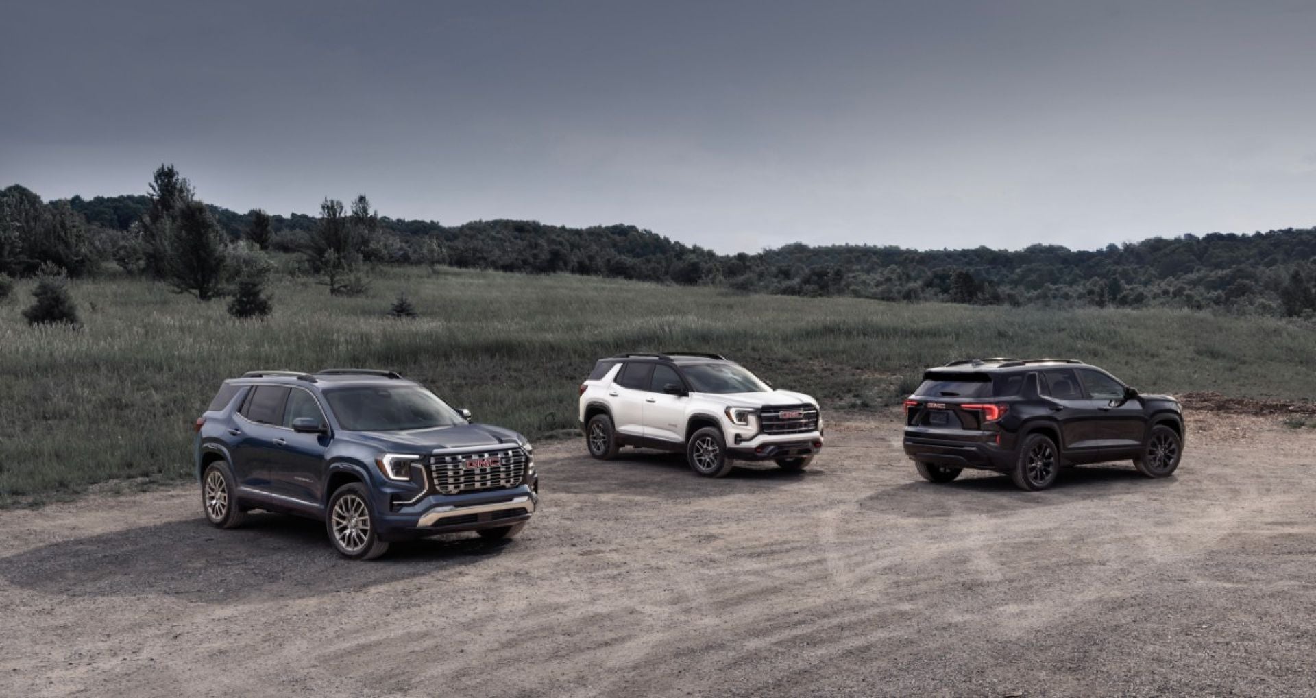 GMC Terrain Denali, AT4 and Elevation parked together on a gravel clearing