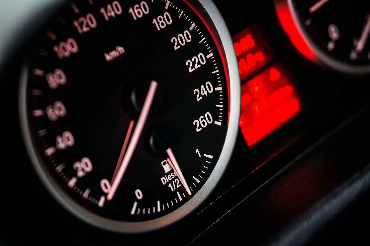 A car's speedometer next to it's dashboard