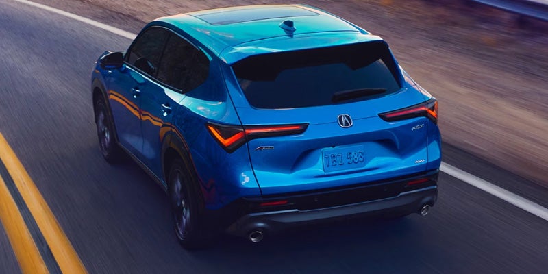 2026 Acura ADX A-Spec Package compact SUV driving on a highway in Grapevine, TX, showcasing sporty styling, sleek LED taillights, and dynamic performance.