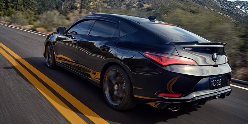 A black Acura Integra A-Spec driving on a mountain road.
