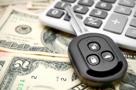 a car key and calculator sitting on top of money 