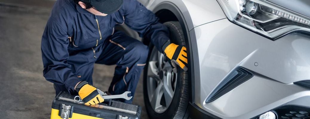 Mechanic checking tires of the vehicle