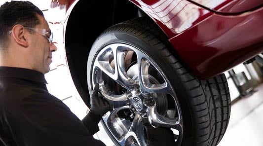 A Buick Certified Technician performing a brake check and replacement on a Buick vehicle