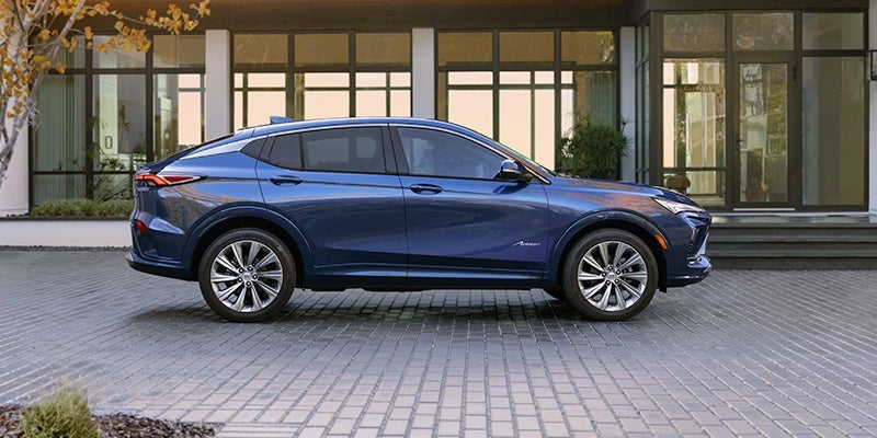A blue 2024 Buick Envista parked on a paved driveway at dusk