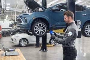 Buick Encore GX in service lane. Service technician checking oil filter