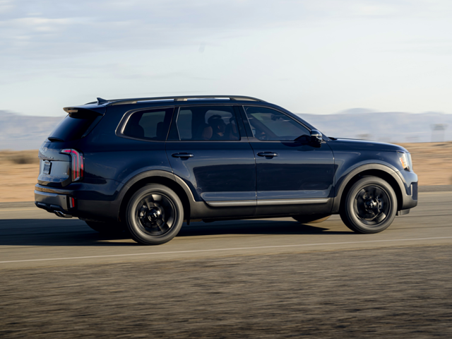 Profile view of a navy blue 2023 Kia Telluride being driven on the road. | Kia dealer in Altoona, PA | Altoona Courtesy Kia